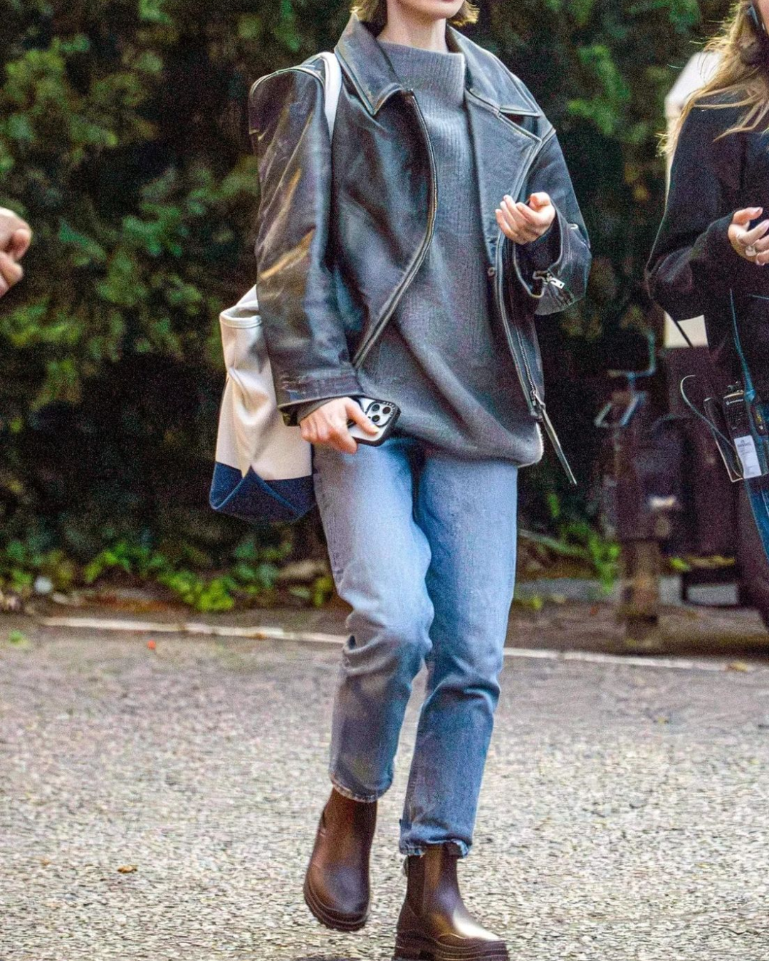 A person walking in straight-leg blue denim jeans that sit perfectly right above the collar of brown leather Chelsea boots.