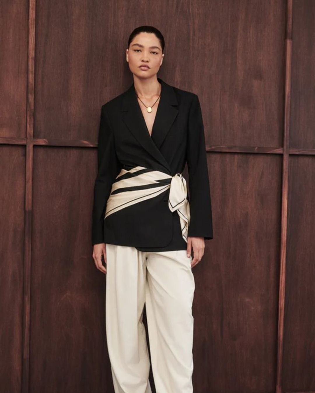 Sophisticated corporate look featuring a structured black linen blazer with a black and white silk scarf tied as a belt, paired with wide cream trousers