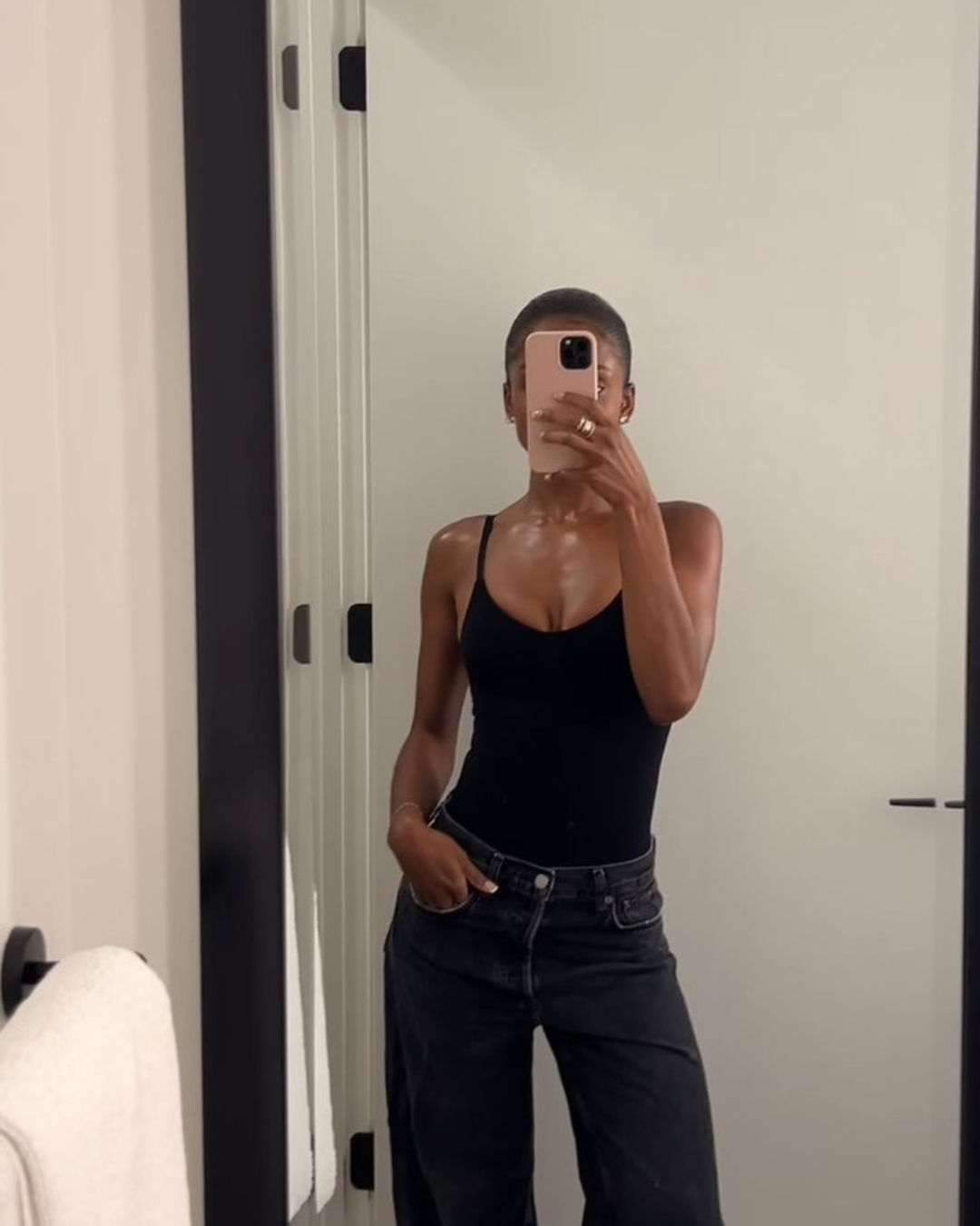 Mirror selfie demonstrating the golden rule of balance with a tight black bodysuit and loose black denim jeans